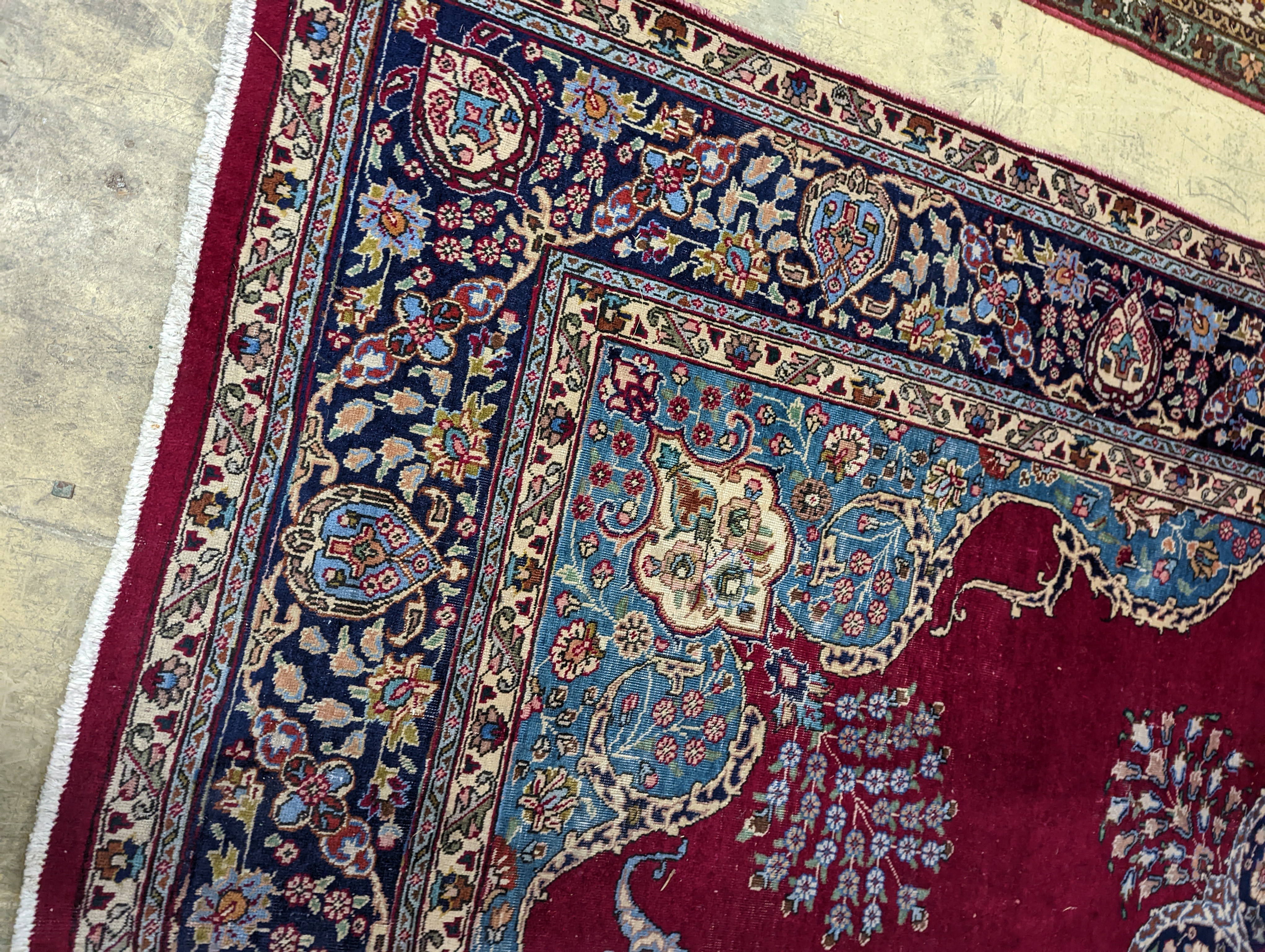 A Tabriz burgundy ground carpet, 350 x 240cm